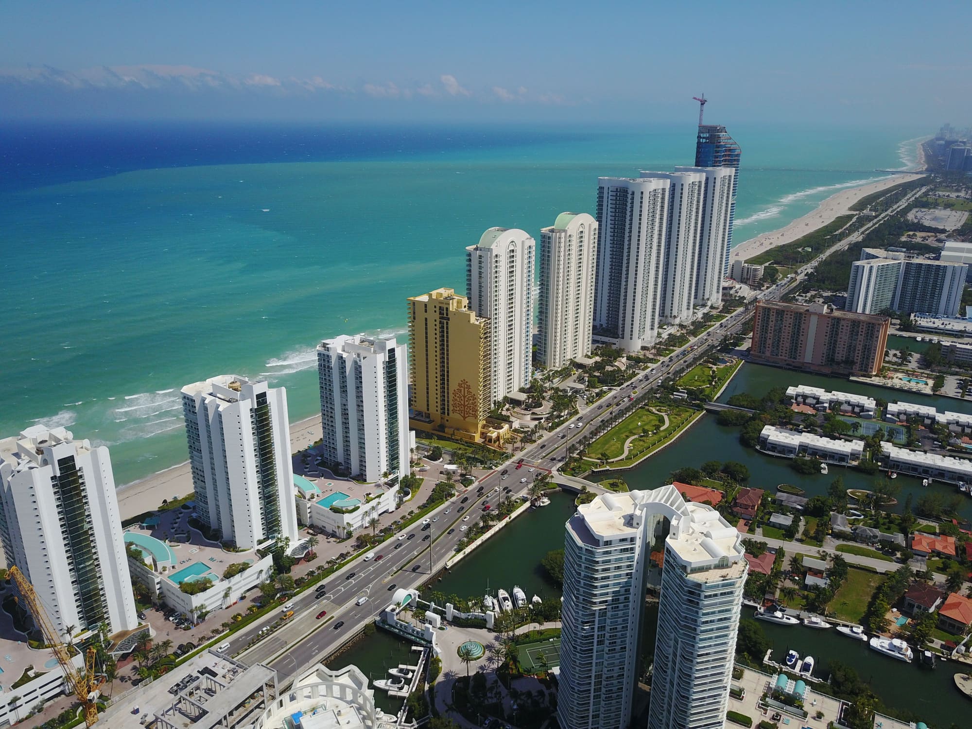Vista aérea de torres residenciales a lo largo de una playa y un canal