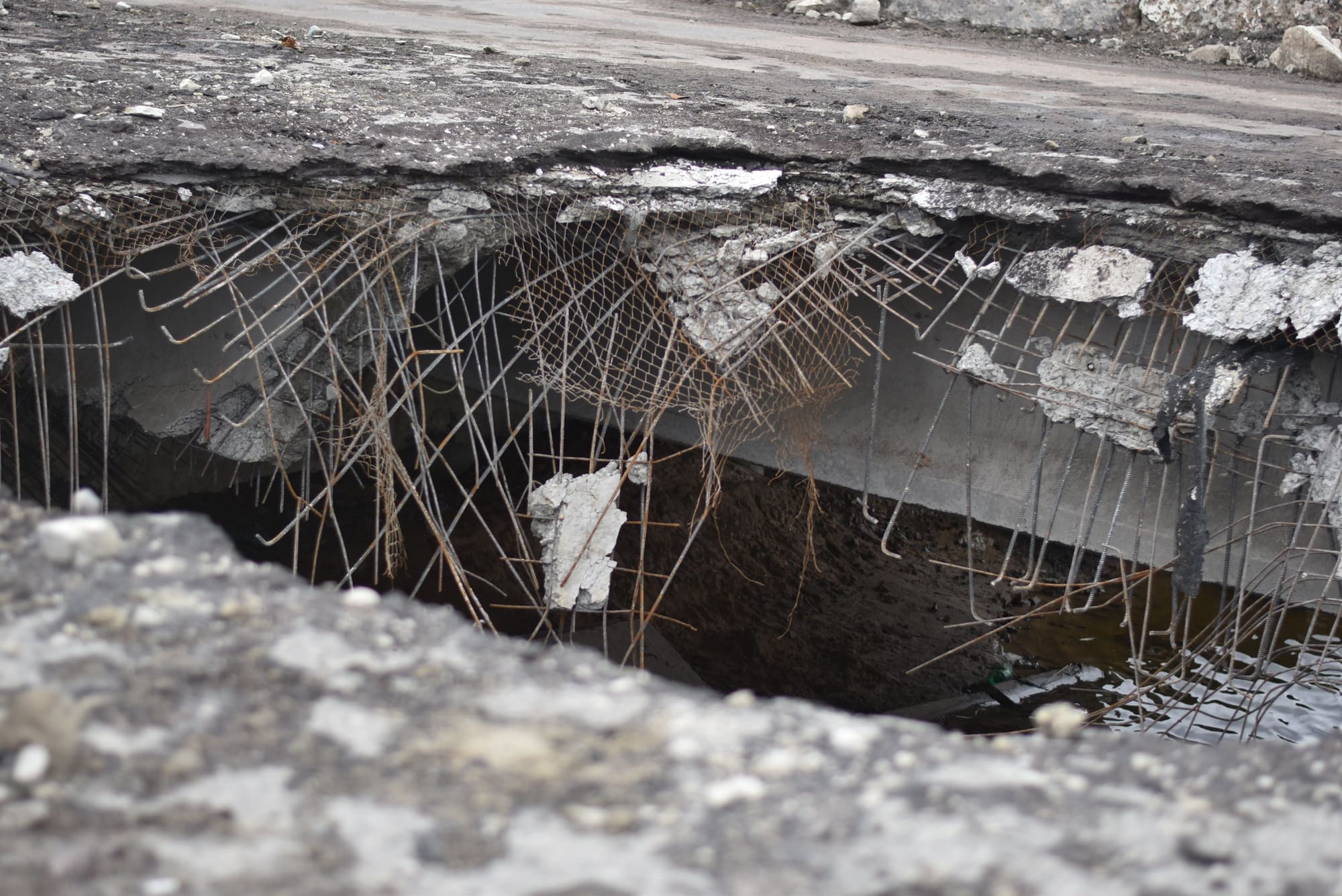 Spalled concrete slab edge with its reinforcing bars exposed